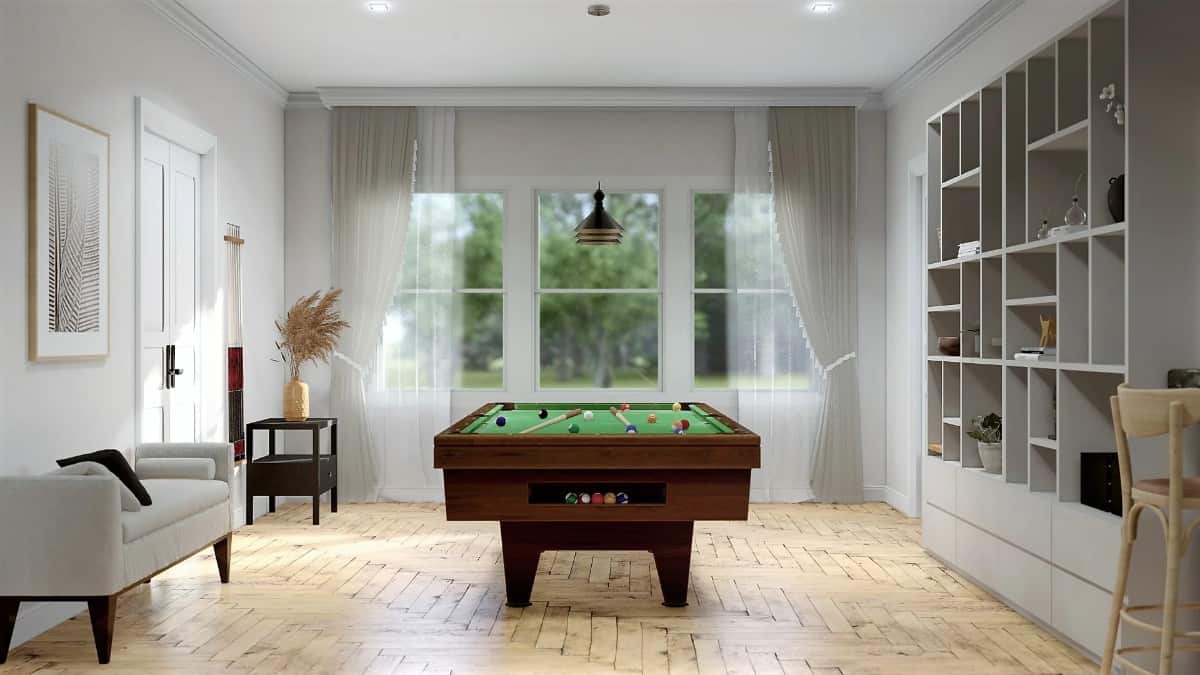 The billiards room has built-in shelves, a modern sofa, and an excellent view of the backyard.
