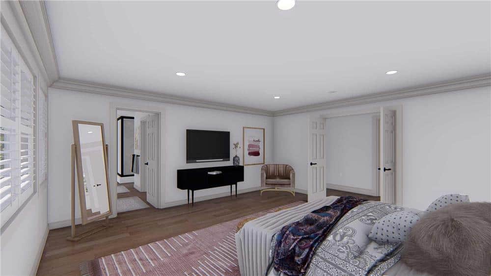 The primary bedroom includes a wall-mounted TV, a round-back chair, and an ensuite bathroom.