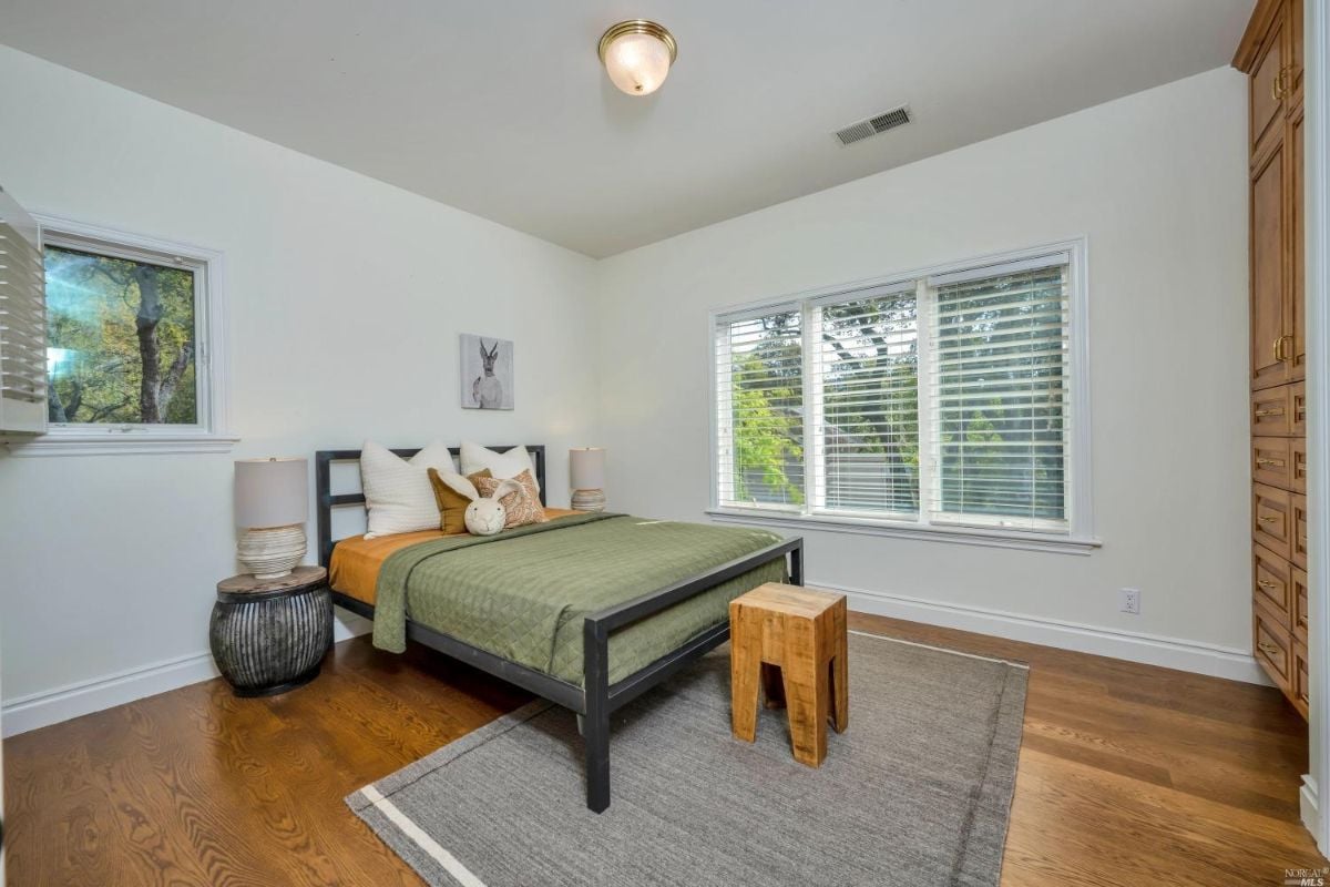 Bedroom with wood flooring and glass windows.