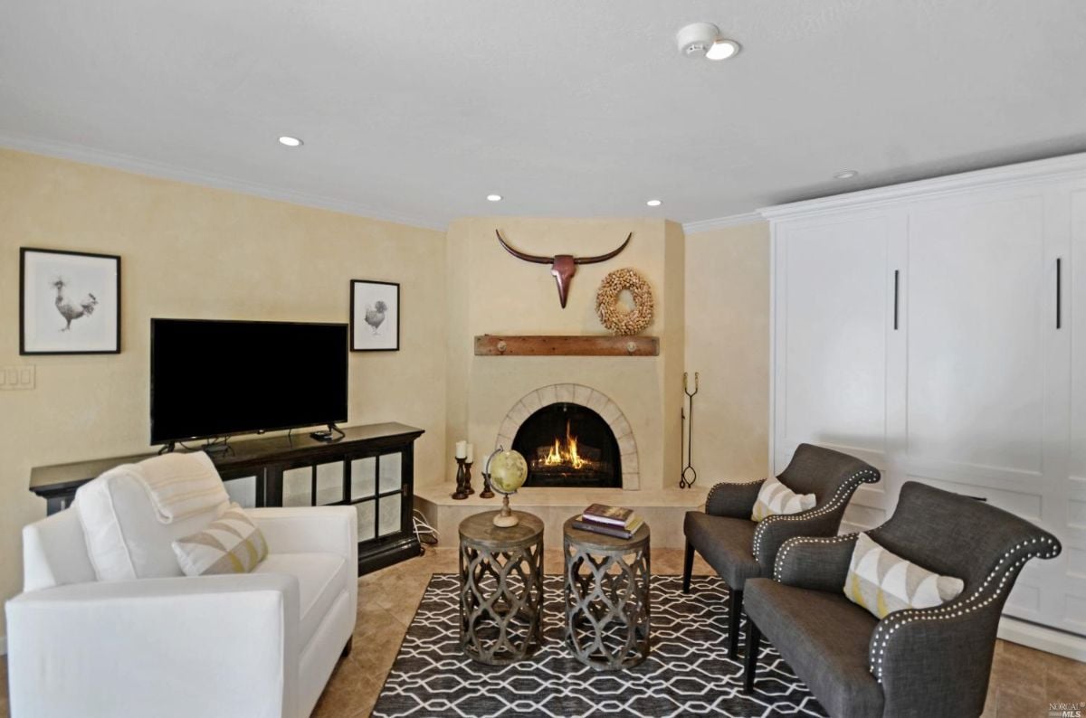 Media room with chairs, fireplace, and a flat screen TV.