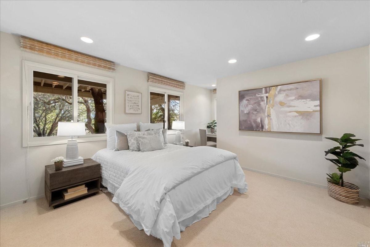 Carpeted bedroom with large glass windows.