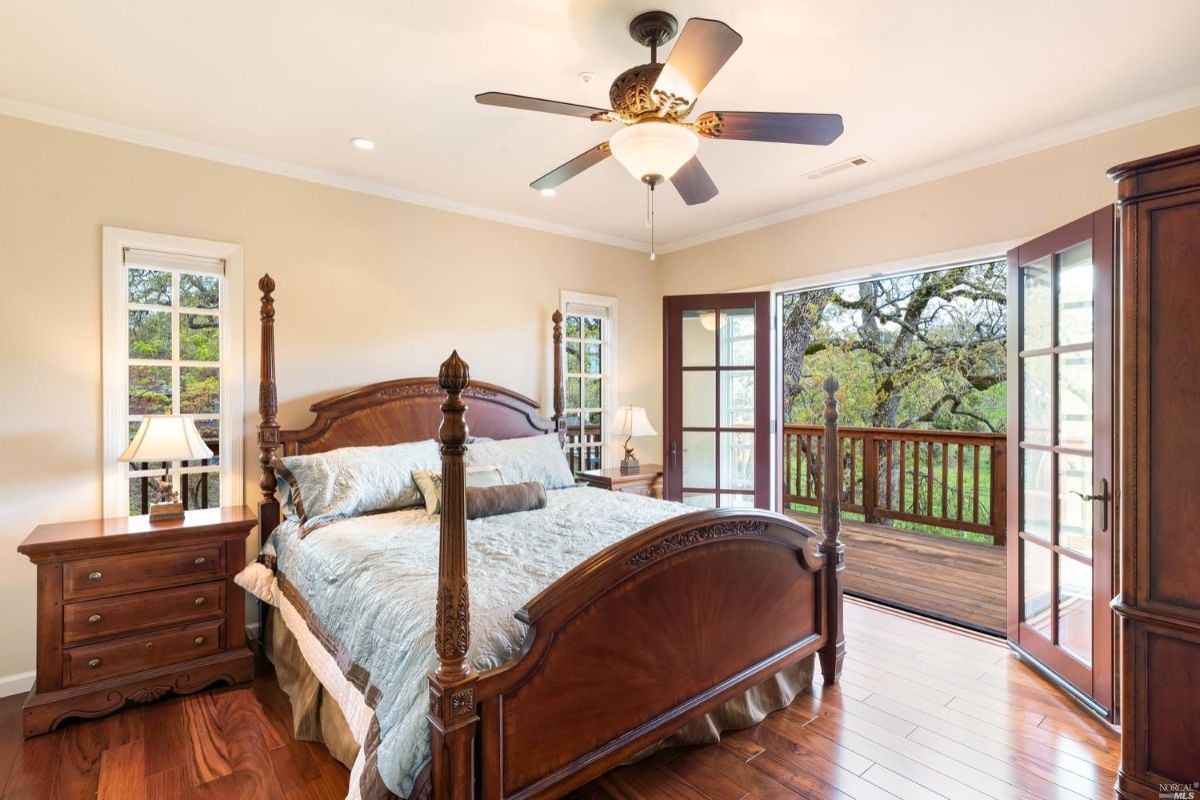 Bedroom with wood floorings and a balcony.