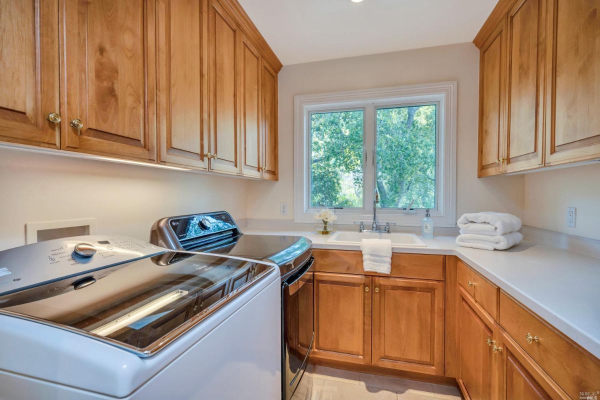 Laundry room with wood cabinets and sink.