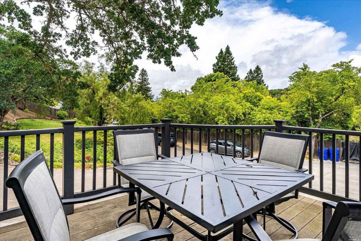 Patio with a table, chairs, and metal railings.