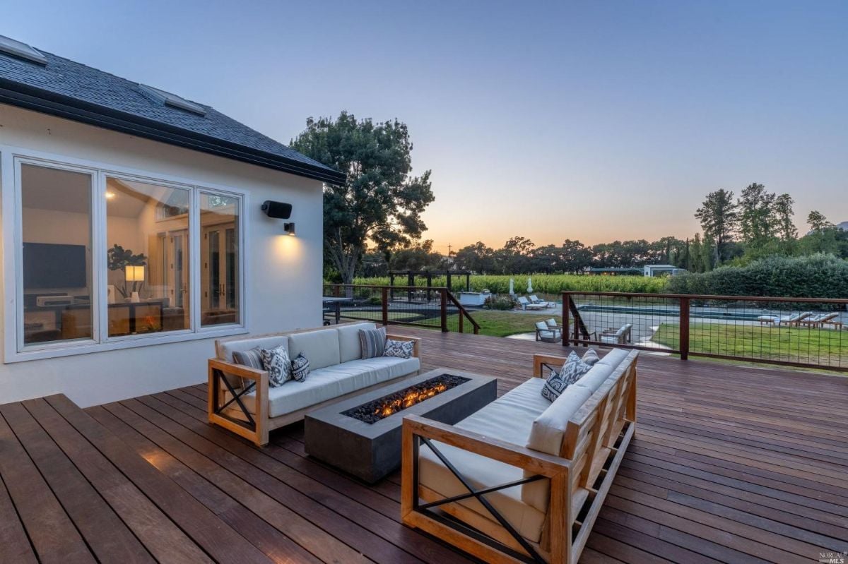 Fire pit on a deck with a couch.