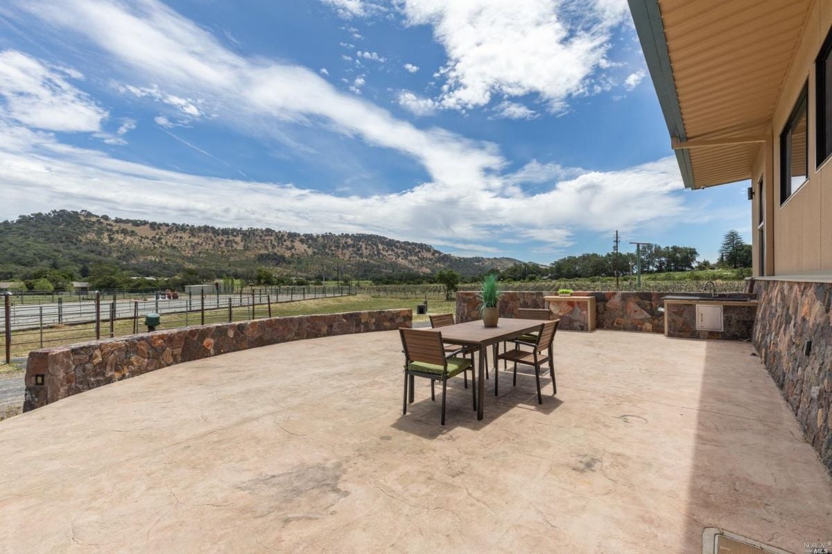 Patio with a table and chairs with a view of the mountains.