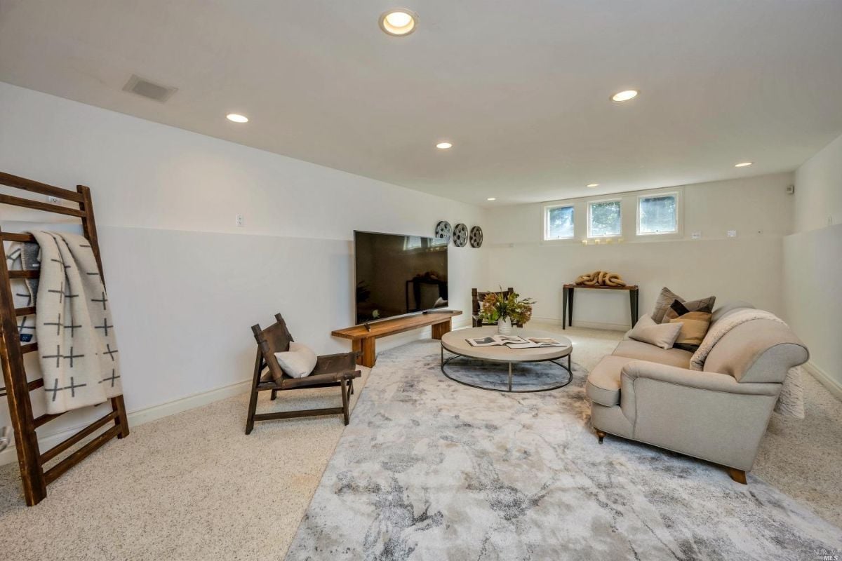 Media room with a huge flat screen TV and couches.
