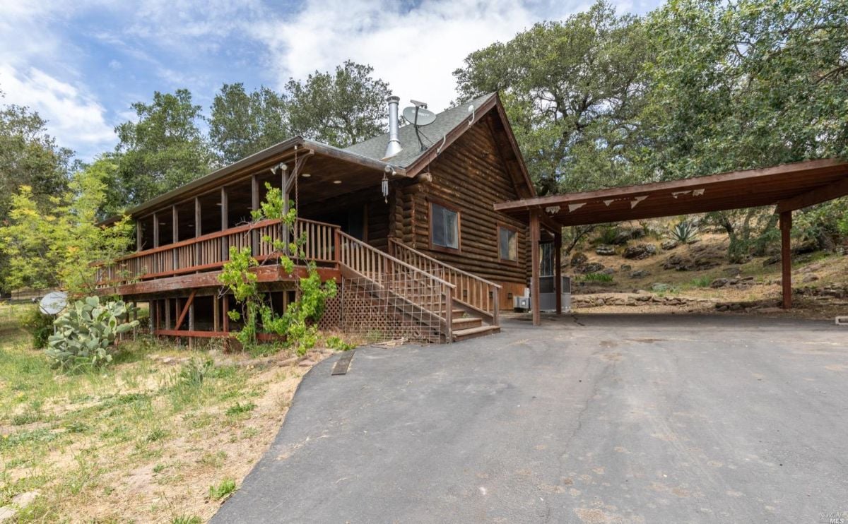 Cabin with a paved driveway.