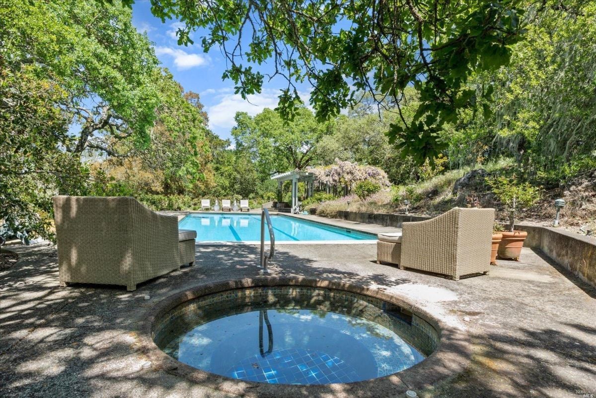 Hot tub in the backyard with a view of the pool.