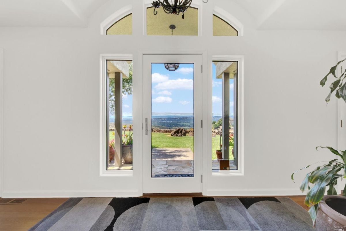 Foyer with a glass door and a rug.