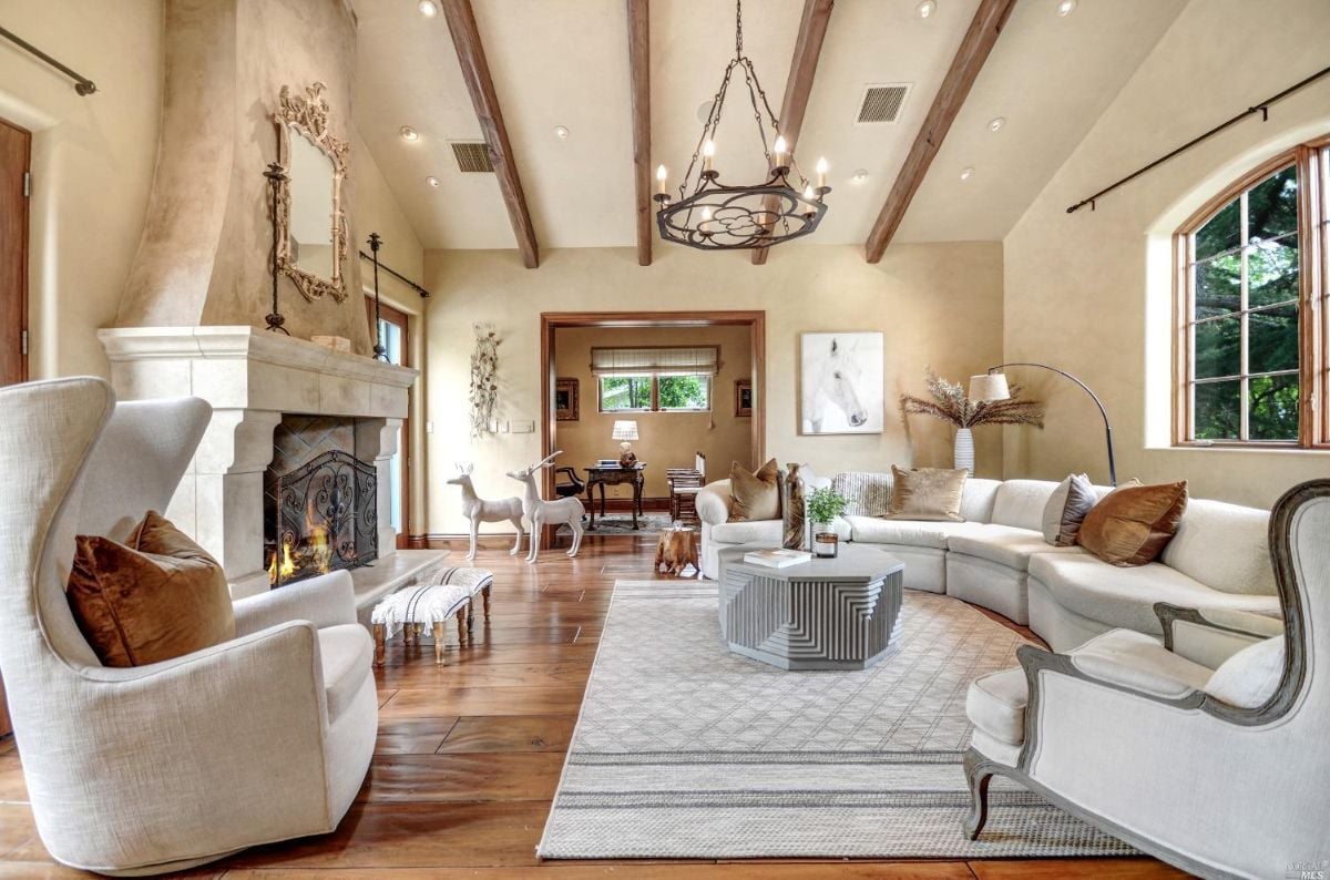 Living room with wood flooring, couches, and fireplace.