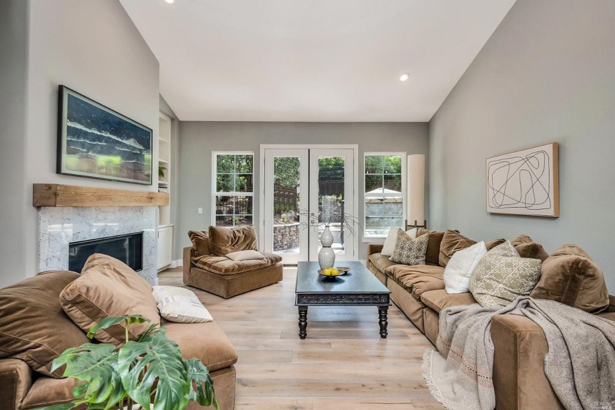 Living room with a fire place and glass doors.