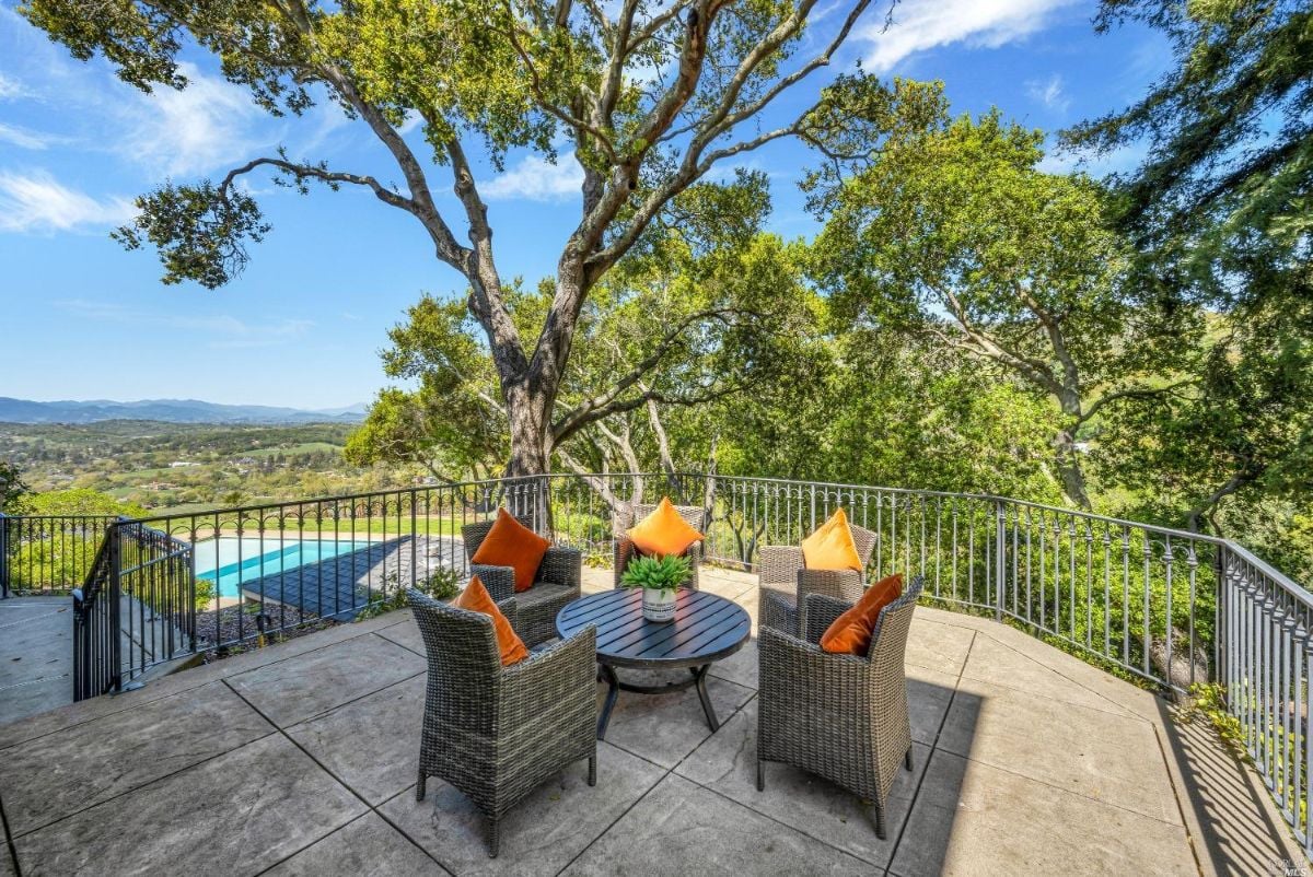 Terrace with table, chairs and overlooking view to the pool.