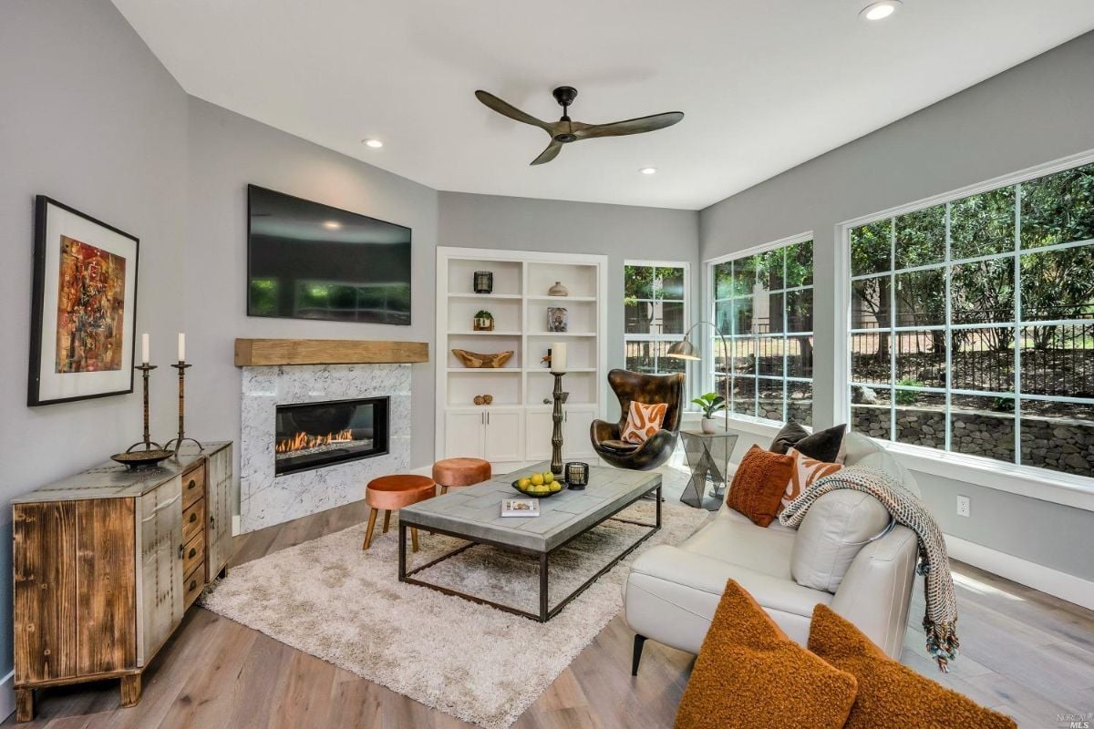 Living room with a fireplace, flat screen TV and couches.