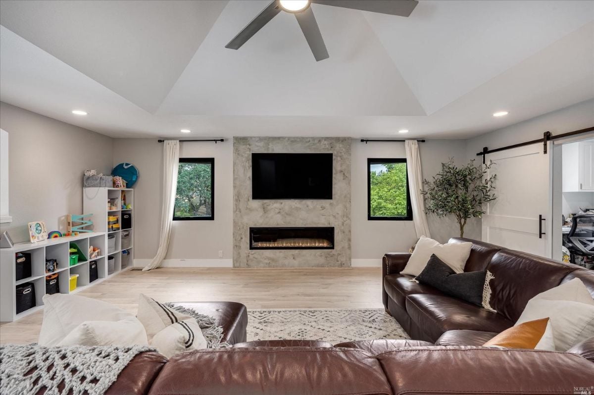 Living room with couches, TV and fireplace.