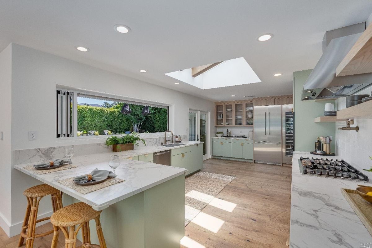 Kitchen with a large island, large window, and a skylight.