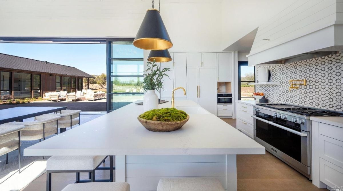 Kitchen with a large Island, slab countertops, and custom cabinetry.