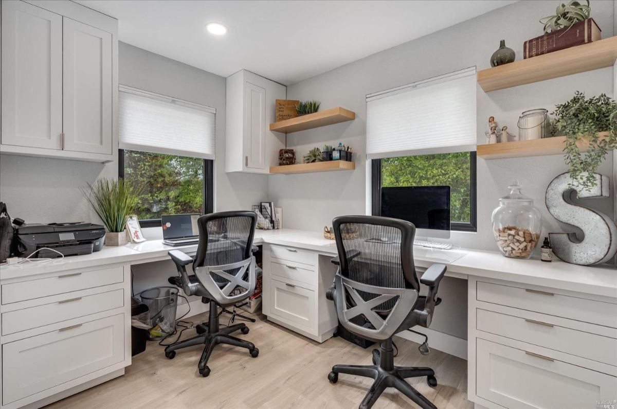 Home office with white cabinets and a desk.