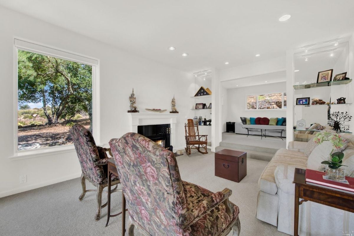 Carpeted living room with a fireplace.