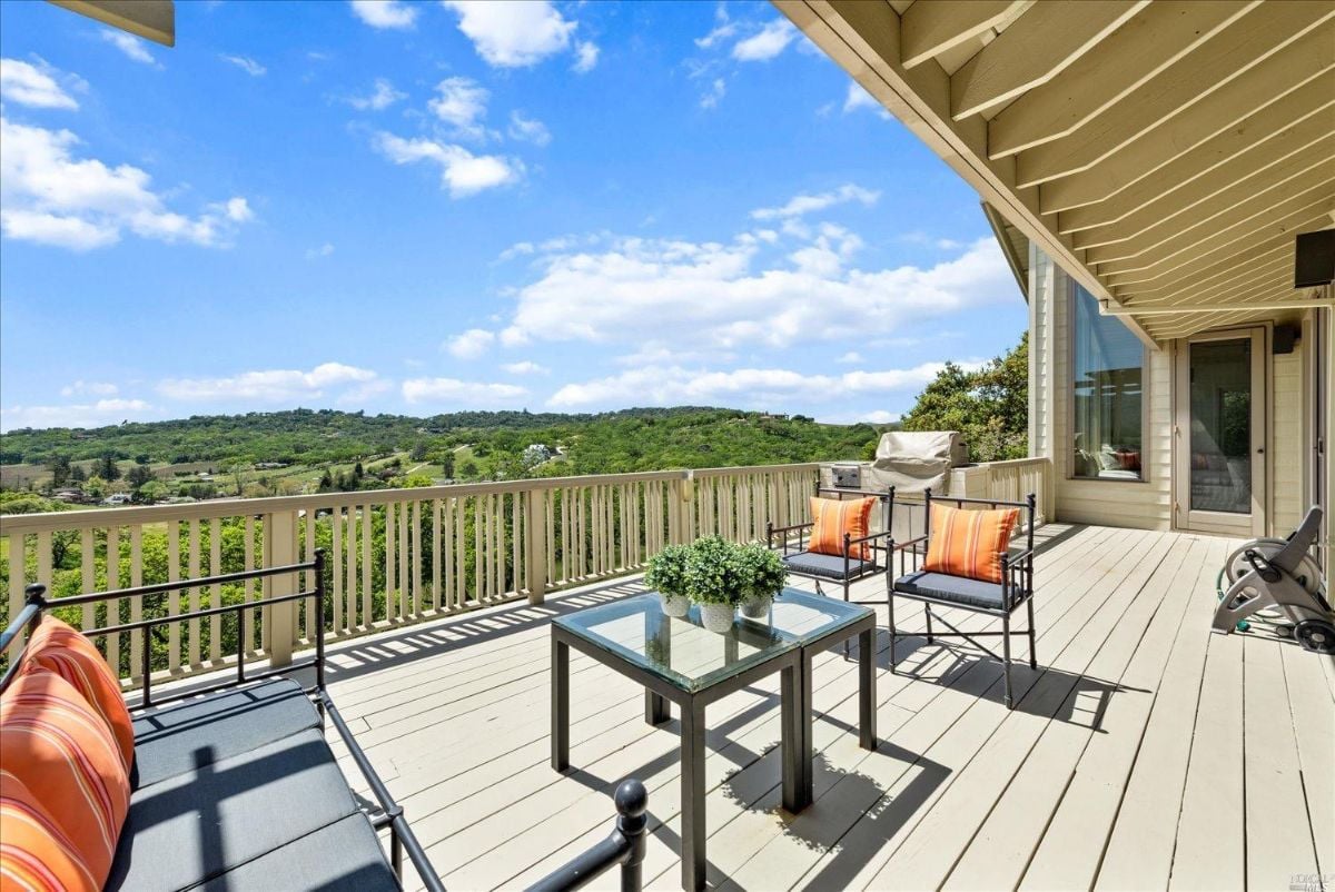 Balcony with a table, chairs, and a view of the mountains.
