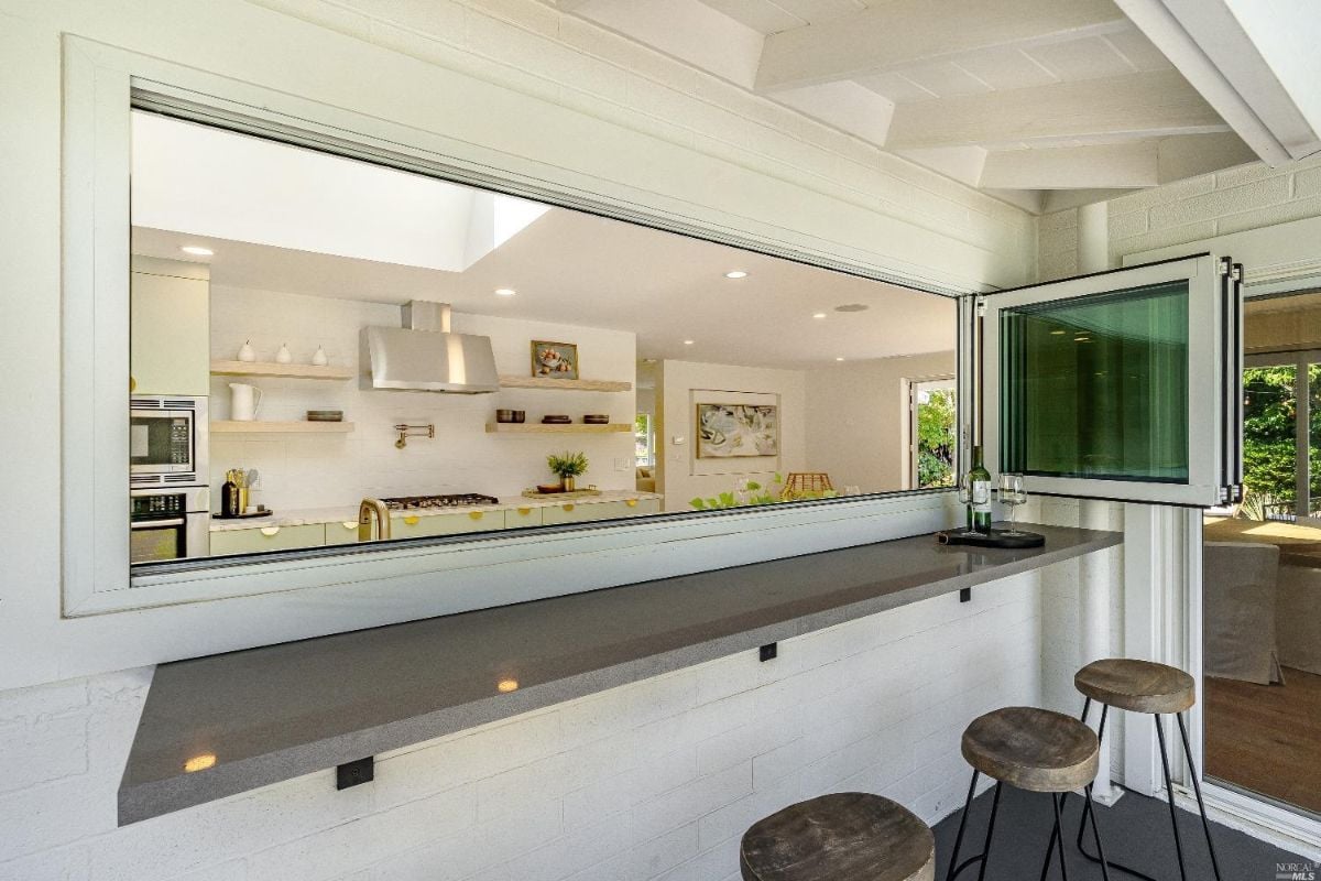 Kitchen with a large window and a bar.