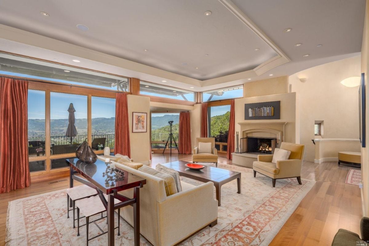 Living room with wood flooring, couches and fireplace.