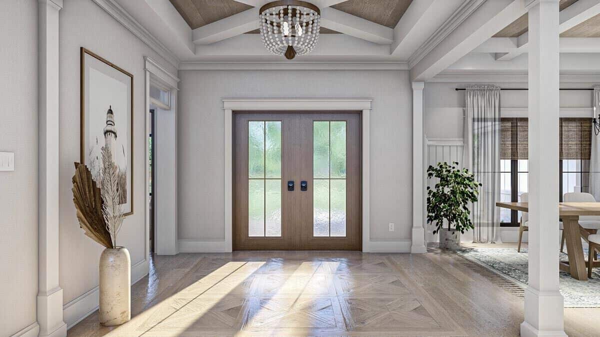Foyer with a French entry door and a tray ceiling adorned with exposed beams.