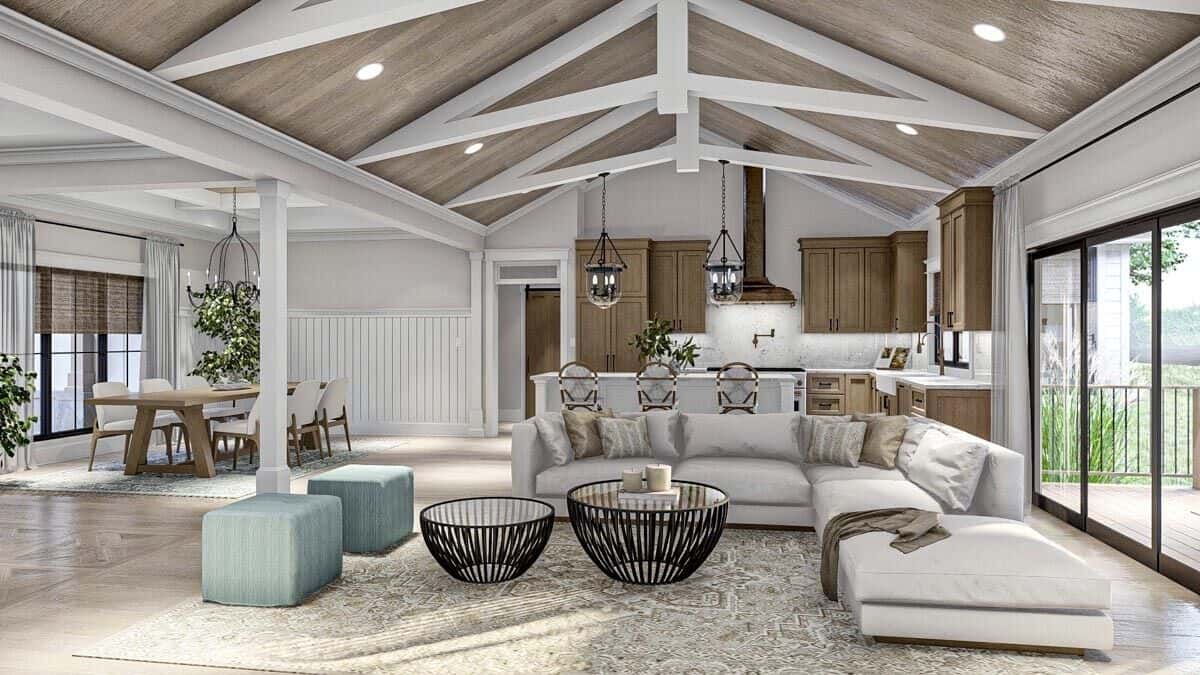 The great room features an L-shaped sofa and a cathedral ceiling that spans through the kitchen.