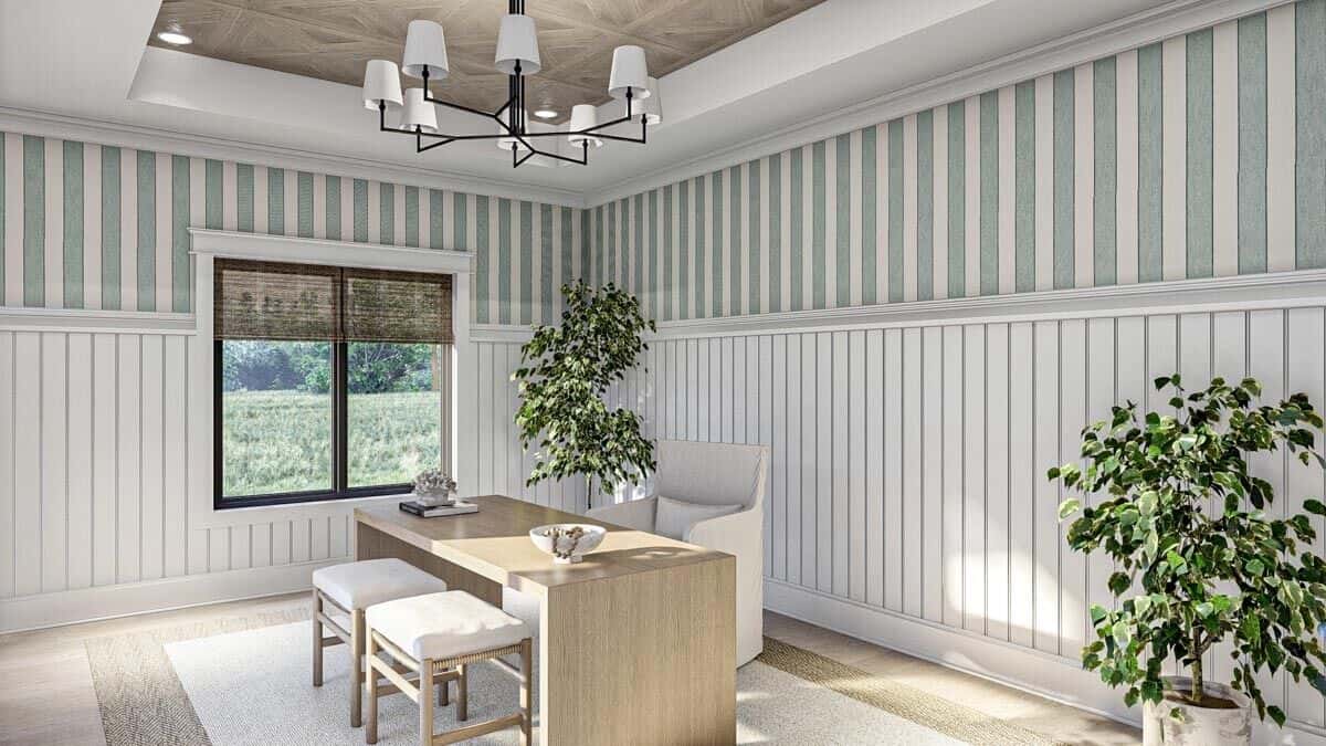 The home office is decorated with beadboard walls, a tray ceiling, and potted plants that bring topical vibes to the room.