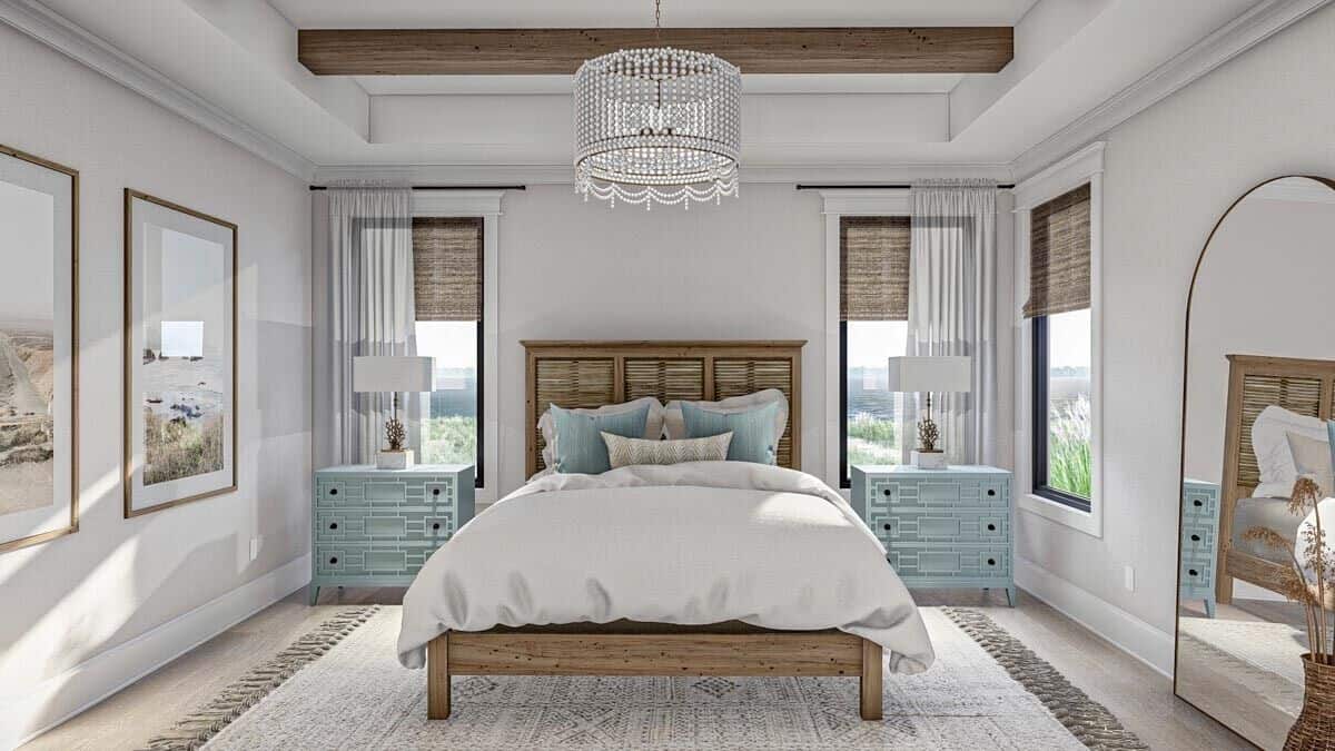 The primary bedroom has also a tray ceiling and a wooden bed flanked by intricate nightstands.