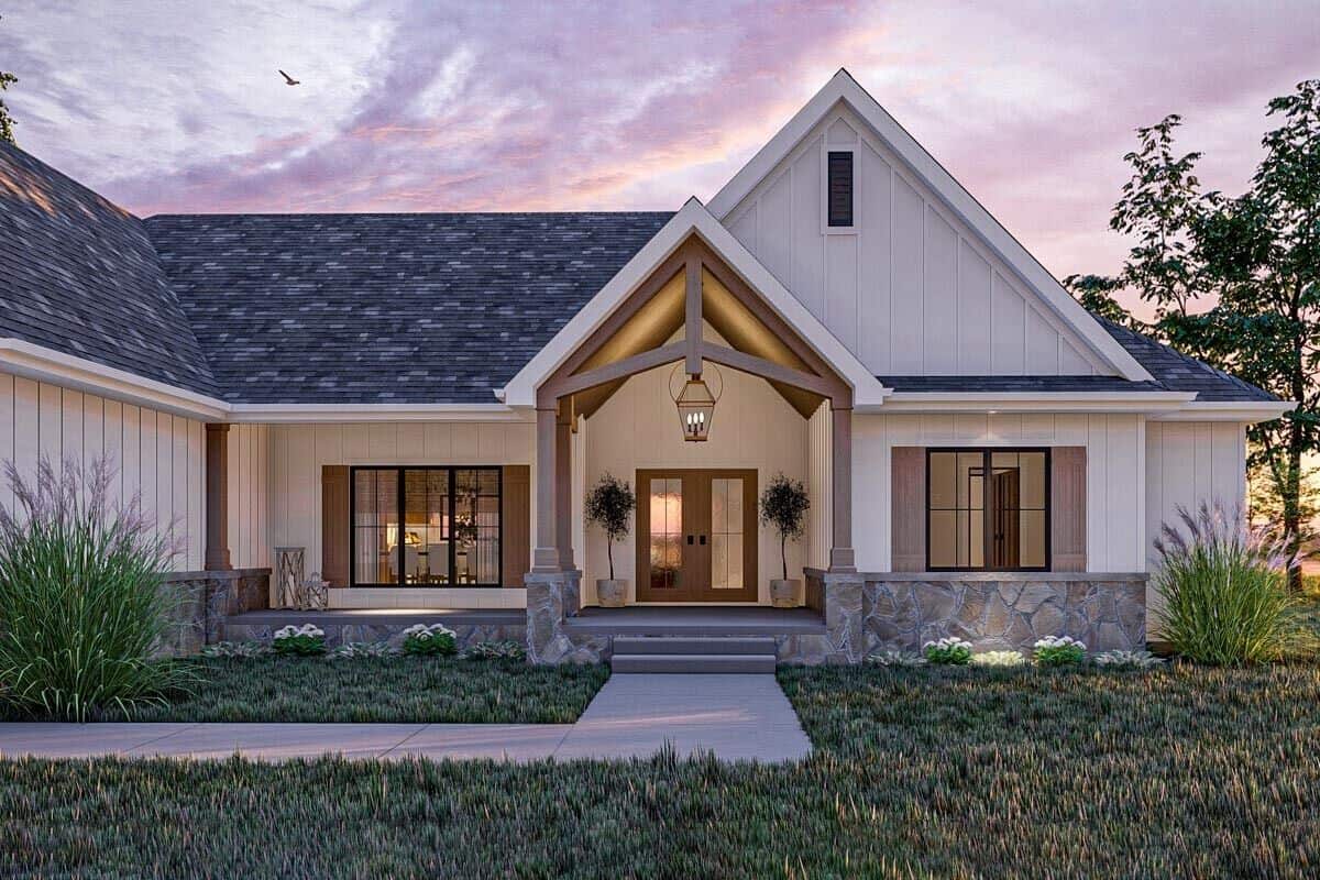 The covered entry porch has a gable roof, a concrete stoop, and a French front door.