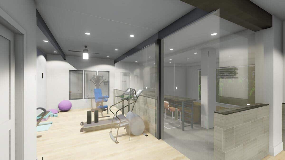 Gym with glazed walls and hardwood flooring.