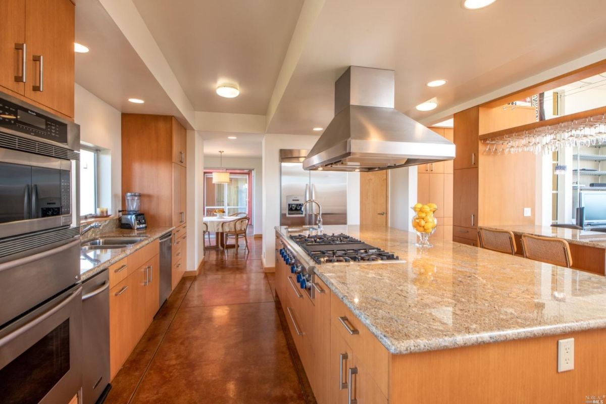 Kitchen with granite counters, stove, huge island and prep sink.