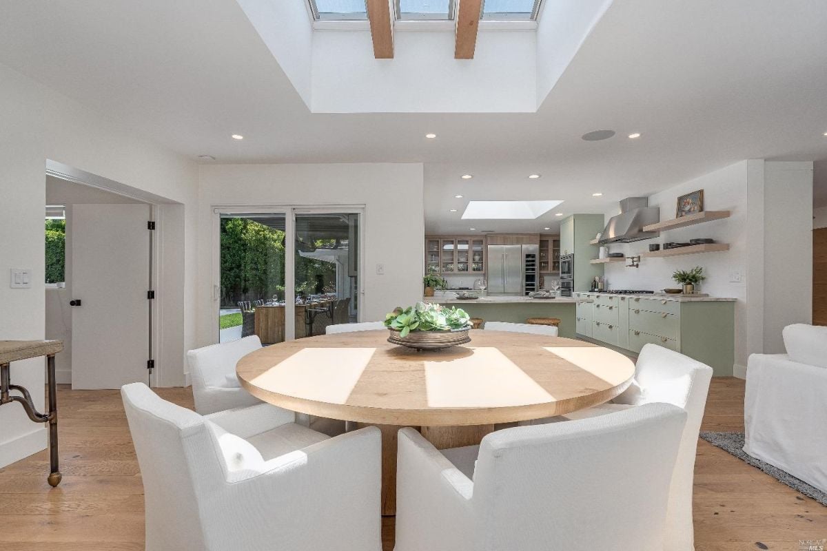 Dining room with a round table and white chairs.