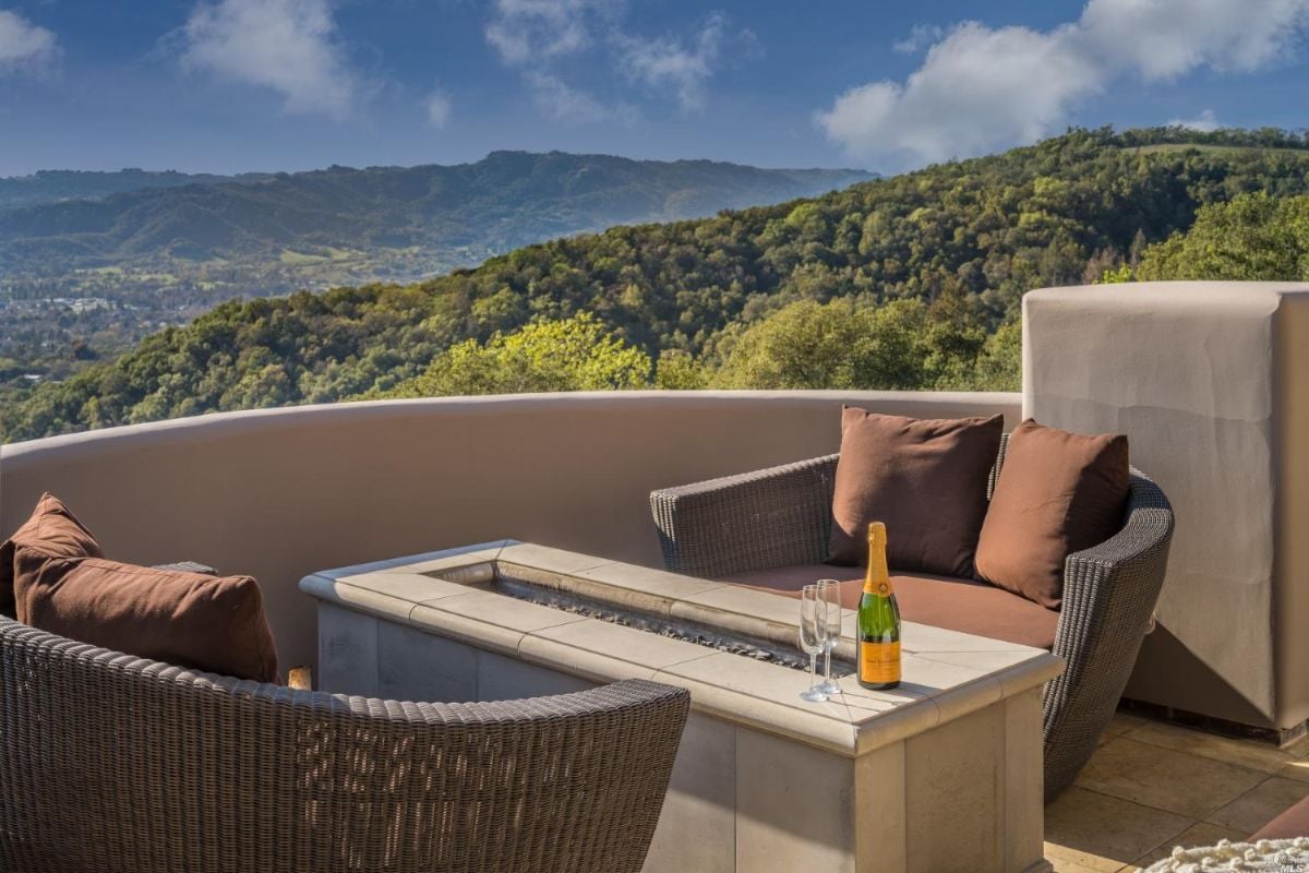 Balcony with chairs, fire pit and a view of the mountains.