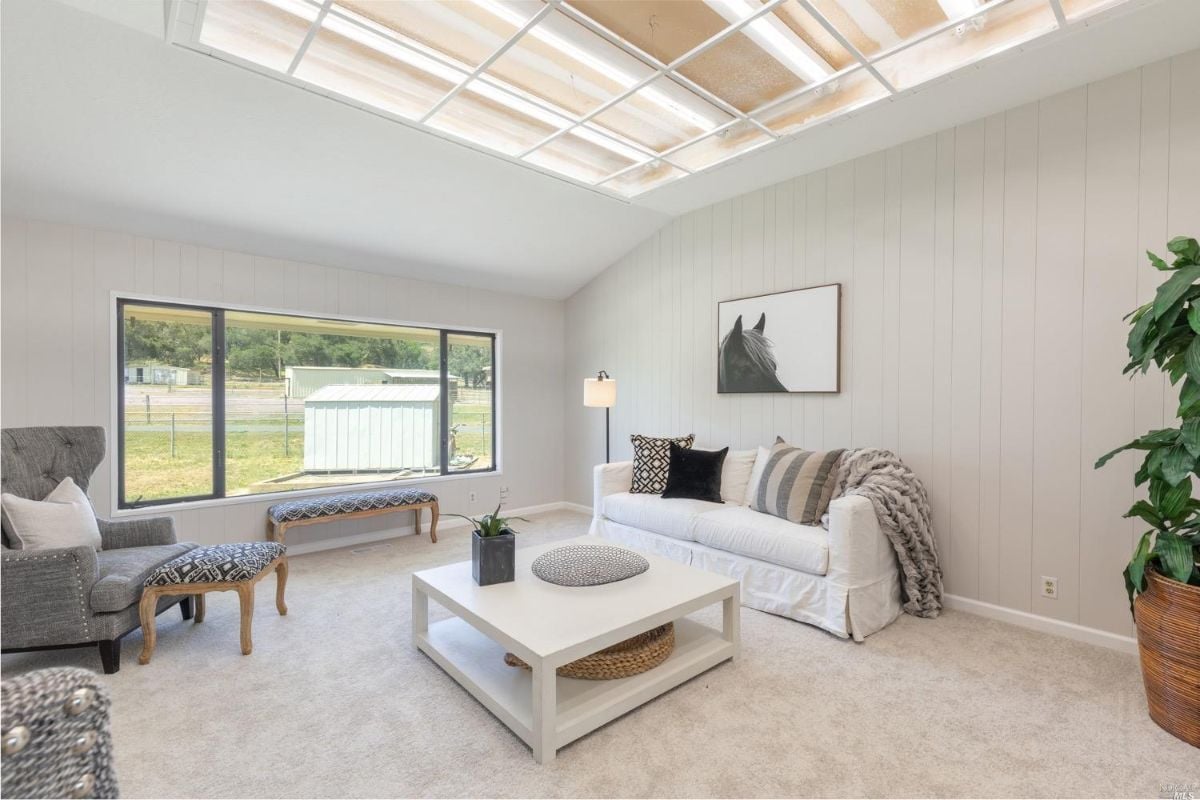 Living room with a large window and a view of the ranch estate property.