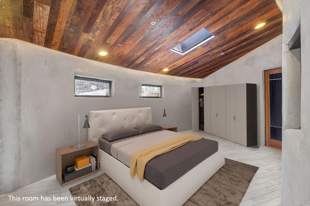 Bedroom with a wooden ceiling and a large bed.