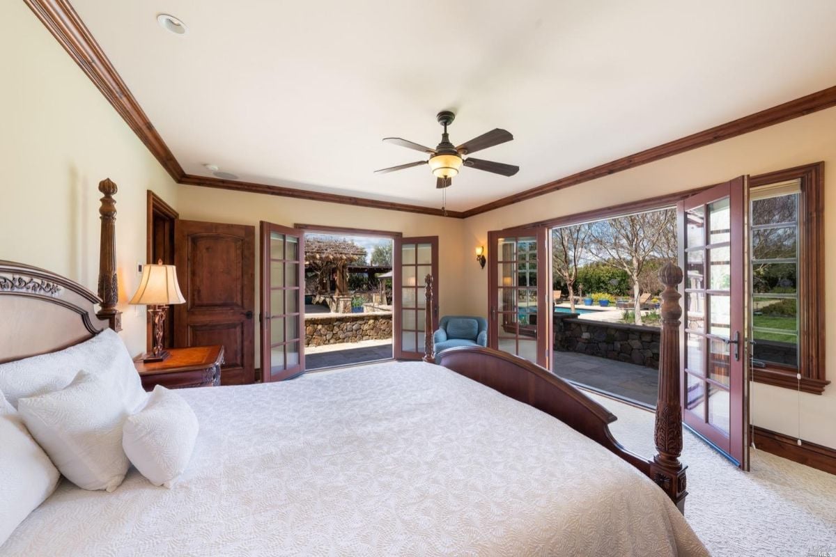 Carpeted bedroom with large doors.