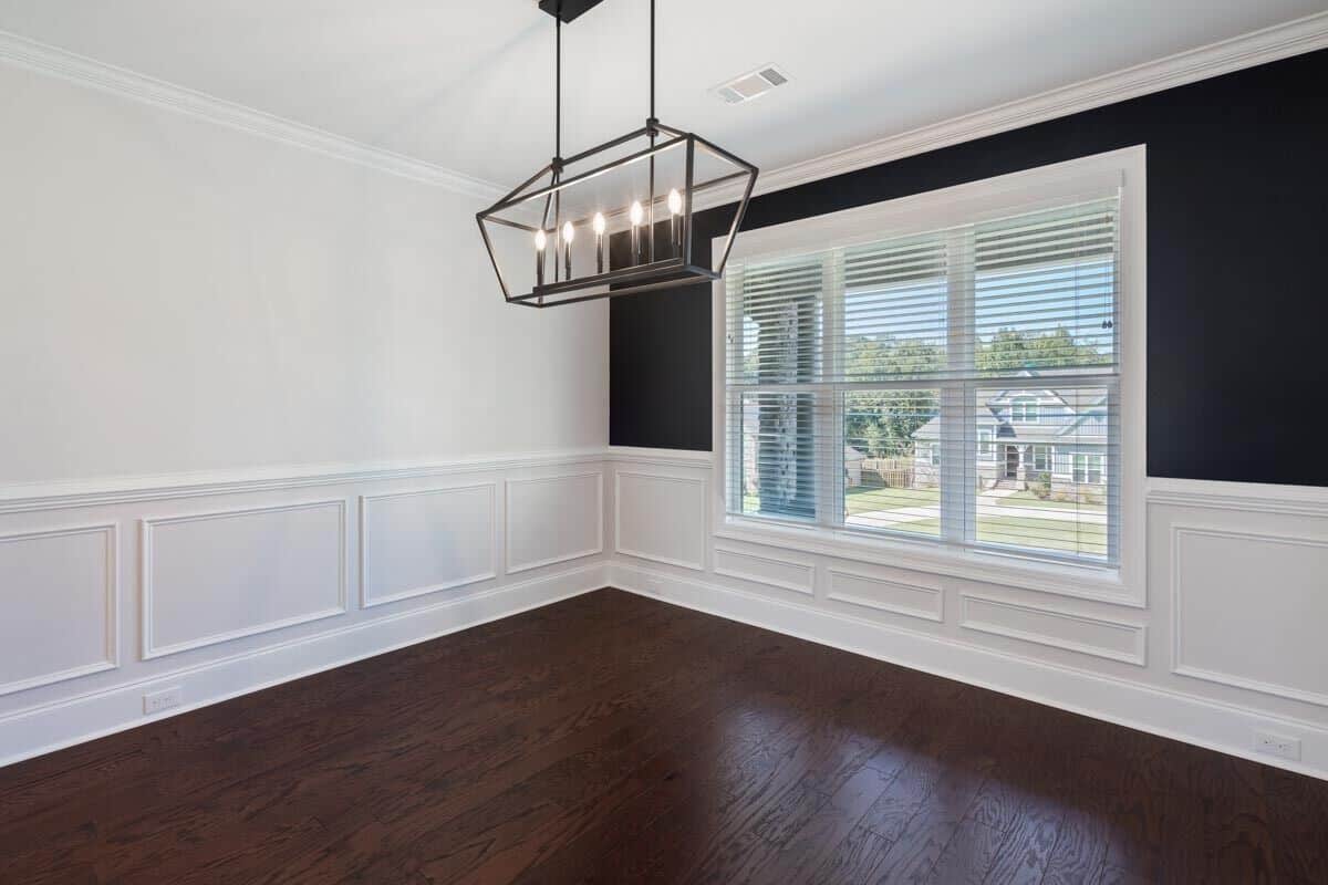 Dining room with black and white walls accentuated with white wainscoting.