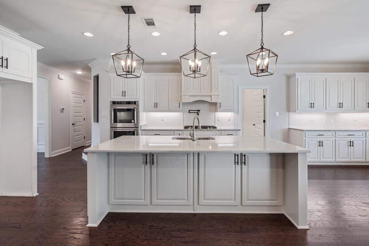 Recessed ceiling lights along with caged pendants suspended over the island illuminate the kitchen.