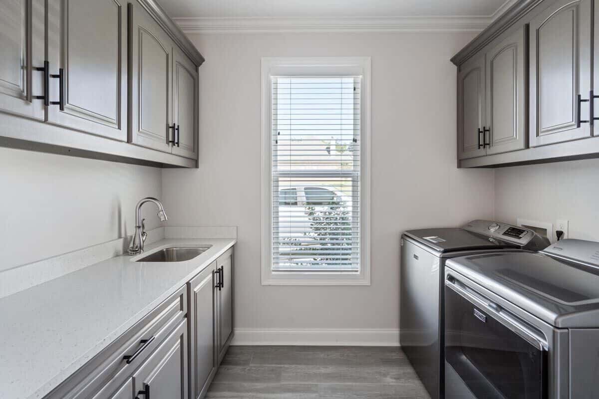 Laundry room with lots of storage, a sink, and top-load appliances.
