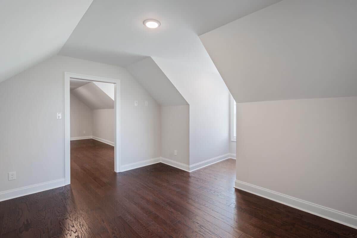 Game room with a vaulted ceiling, hardwood flooring, and knee walls.