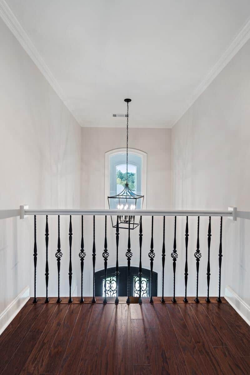 Second-level balcony with wrought iron railings overlooking the foyer below.
