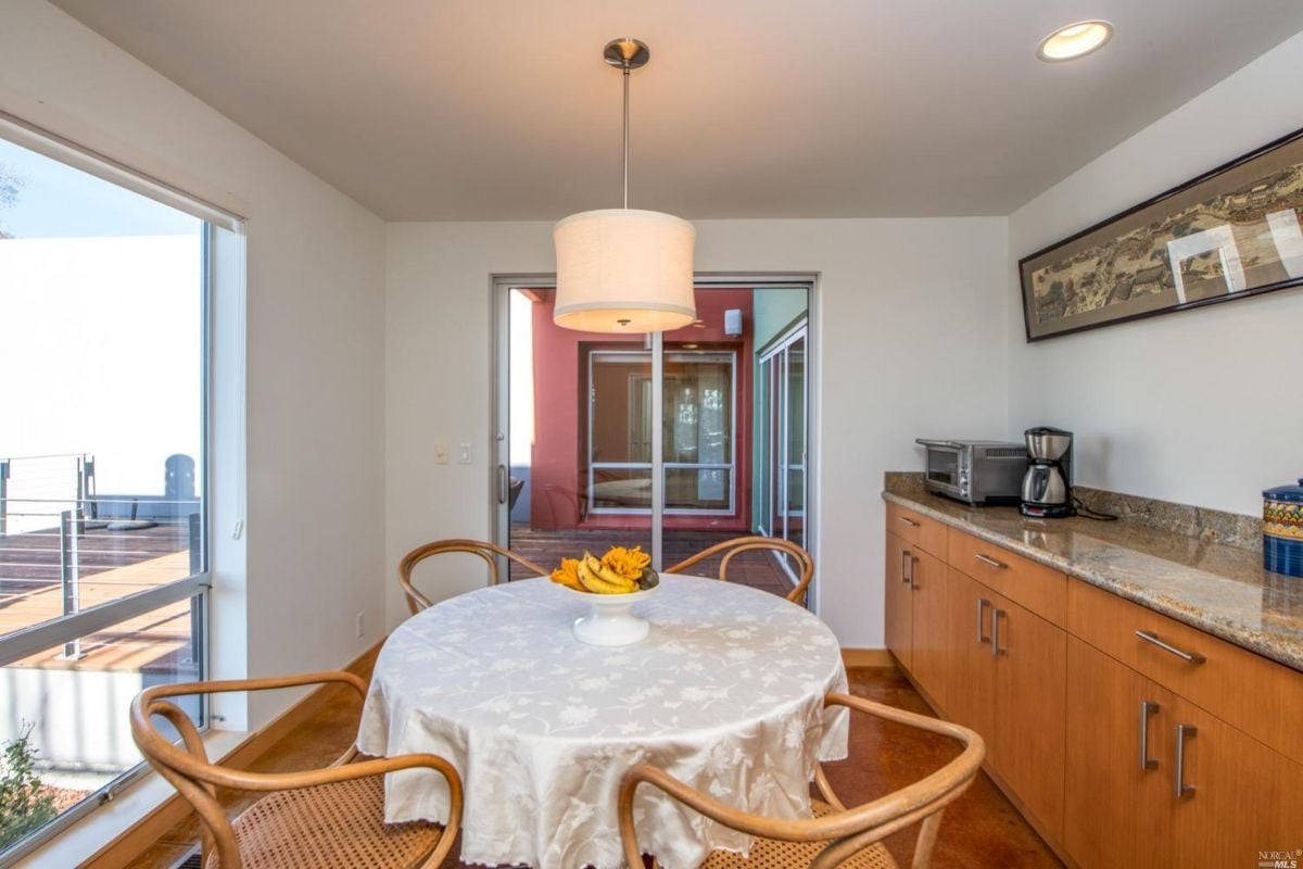 Breakfast room with huge glass window, sliding glass doors and a sink.