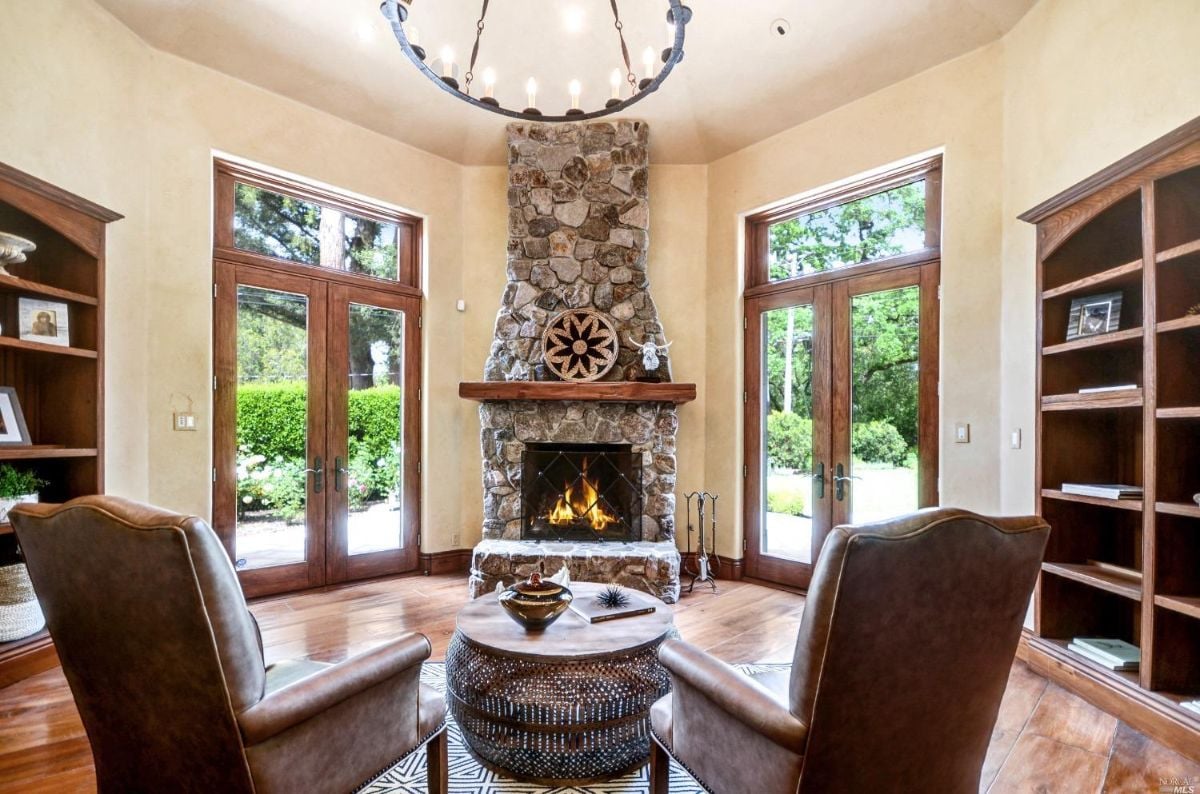 Fireplace with glass doors and wood flooring.