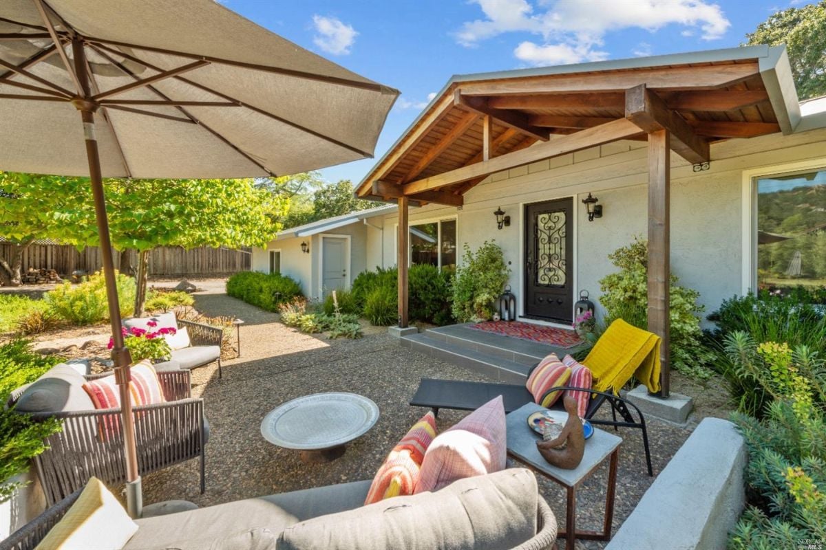 Patio with a table and chairs under an umbrella.