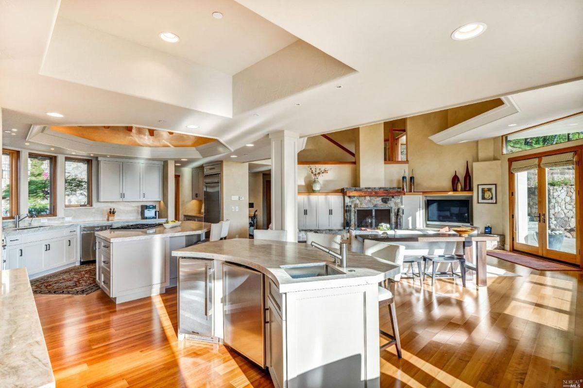 Kitchen with wood flooring, slab countertops, and custom lighting.