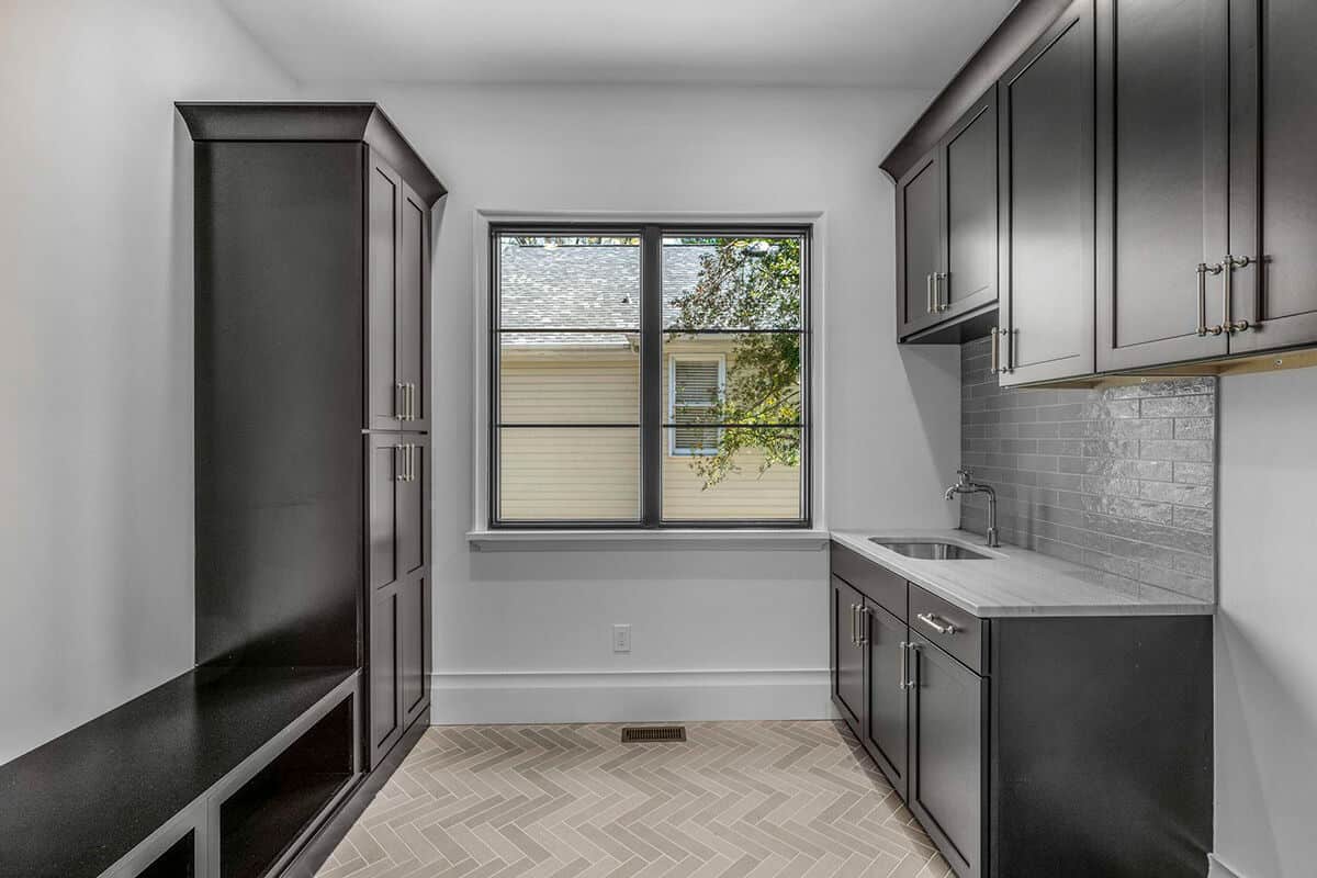 Laundry room with additional storage, a built-in bench, and a sink.