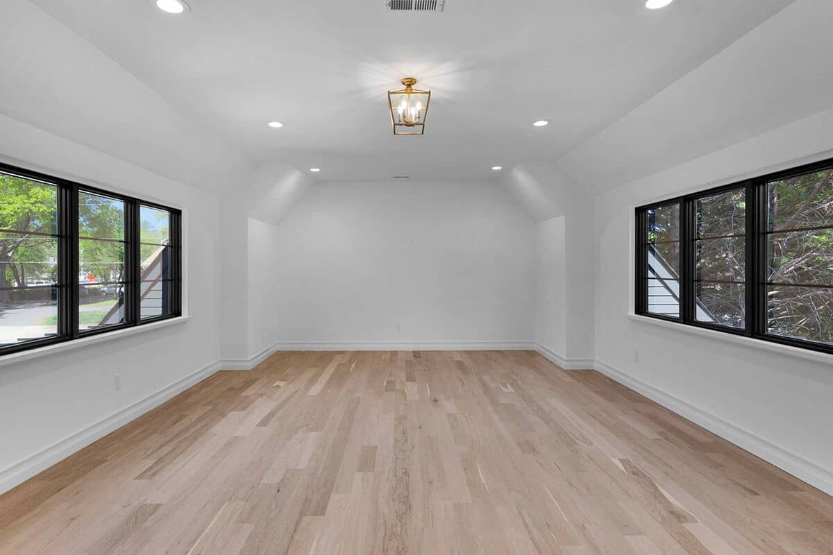 Bonus room with a vaulted ceiling, hardwood floor, and aluminum-framed windows allowing lots of natural light in.