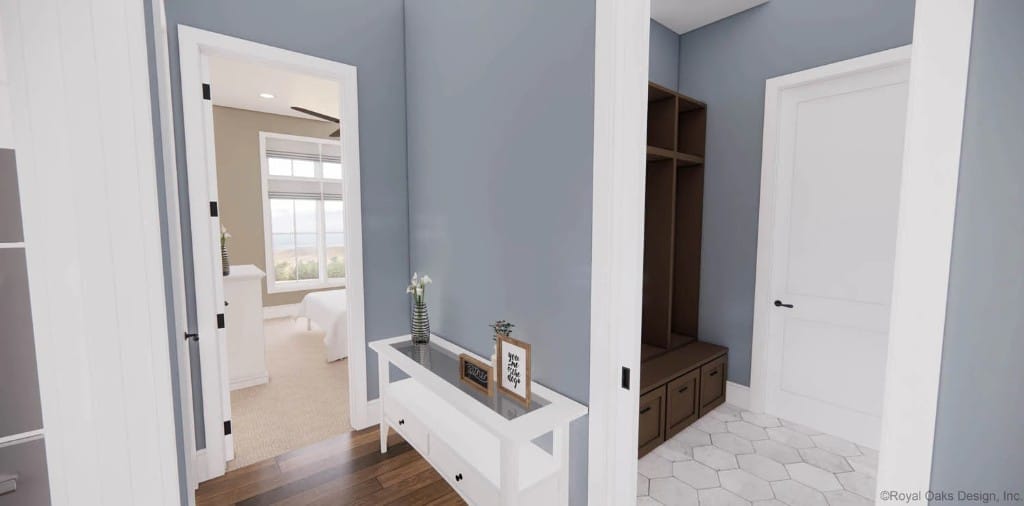 Hallway with a glass-top console table leading to the mudroom and bedroom.